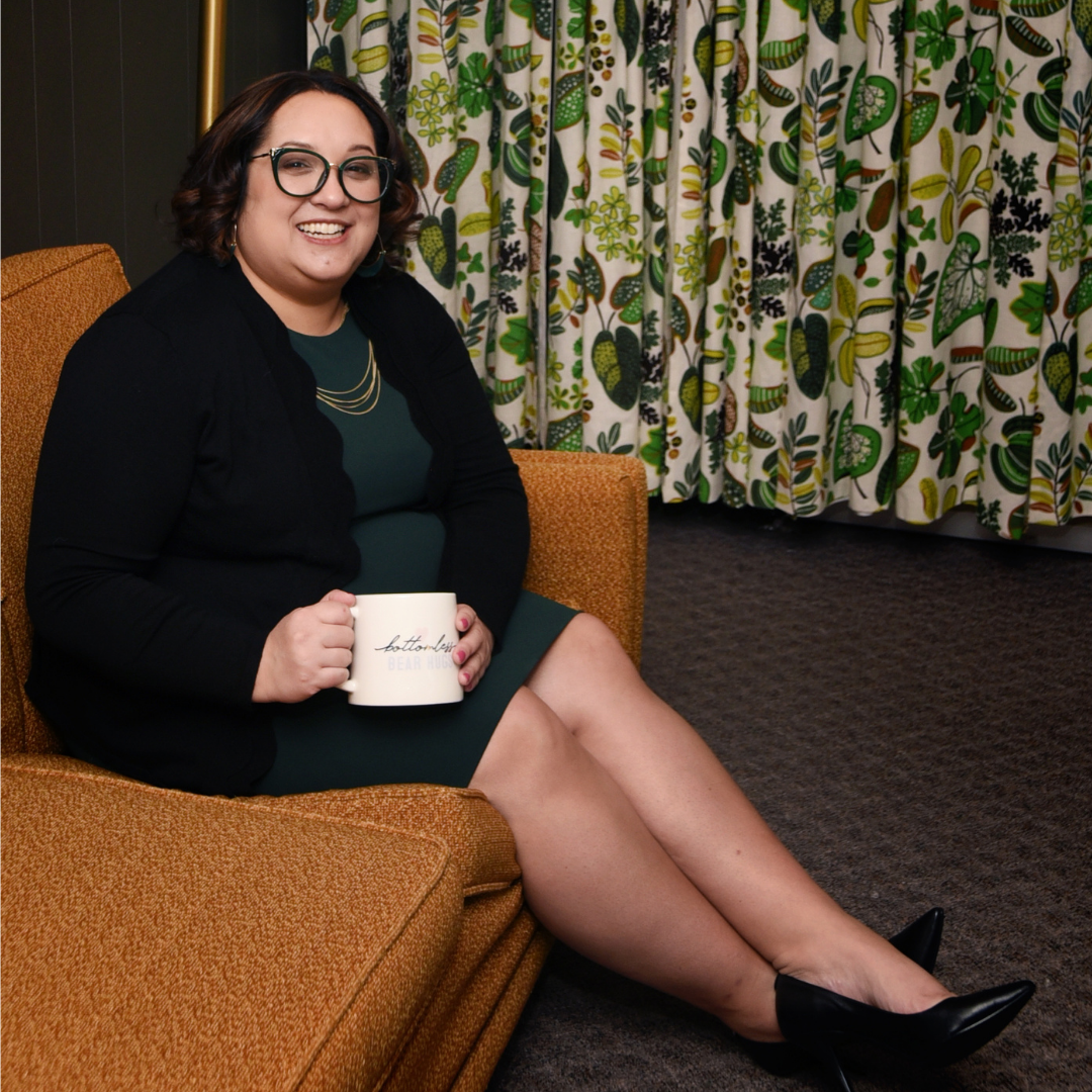 Samm Smeltzer founder of The HRart Center sitting on a yellow couch